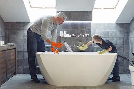 Father and son cleaning bath together.