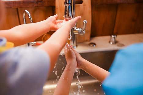 Kids washing hands together increases water usage efficiency to prevent damage to your septic system.