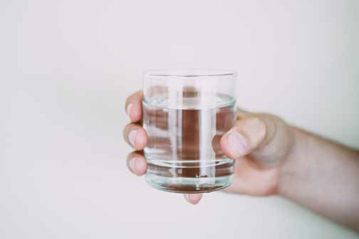  A person holding a glass of water.