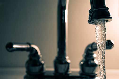 Stainless faucet and water coming out.