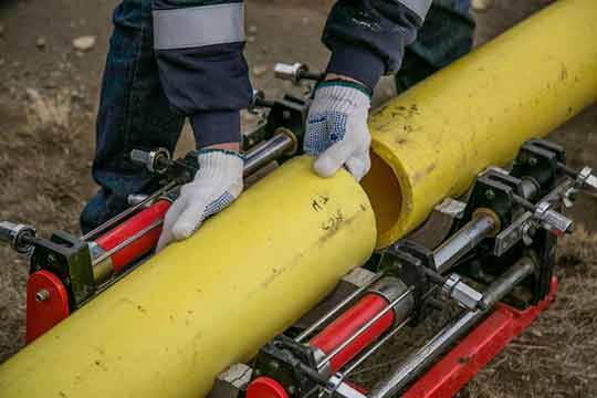 plumber holding a yellow pipe.