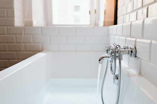 A white bathtub and a stainless steel faucet.