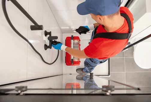 a plumber repairing apartment plumbing fixtures.