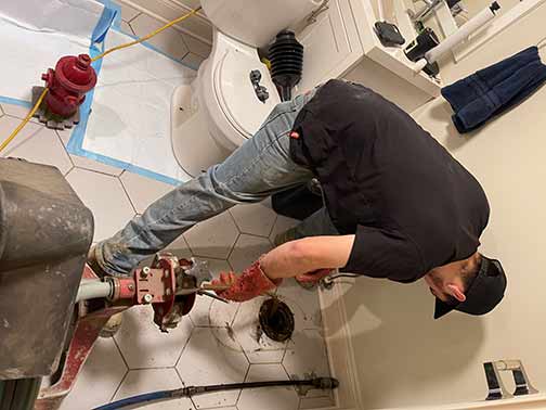 a plumber performing a drain cleaning service