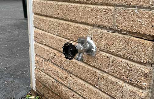 an outdoor faucet that has been freshly repaired.