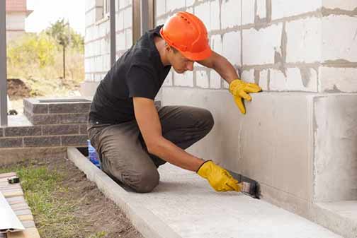 a person sealing their foundation to prevent flooding