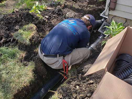 a plumber installing a french drain system in chicago.