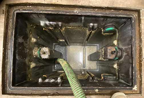 plumbers cleaning out a grease trap in a chicago restaurant