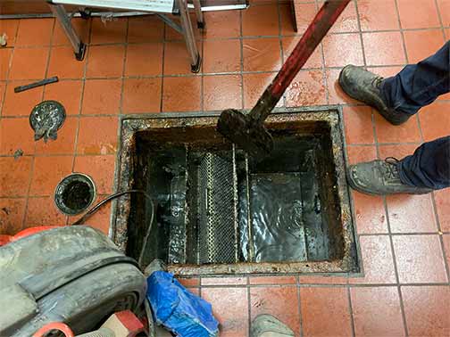 a plumber making a grease trap repair.