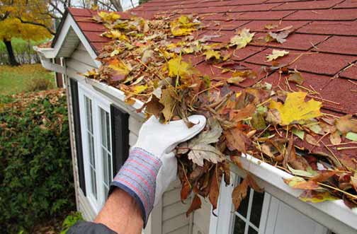 a man cleaning out his gutters.