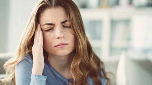 a woman with a headache from the smell of sewer gas odors