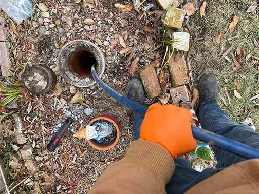 a plumber performing a hydro jetting on a blocked sewer line.