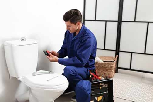 a plumber installing a toilet.