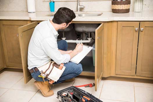 a plumber in chicago fixing plumbing code violations.