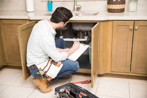 a plumber doing an inspection on pipes