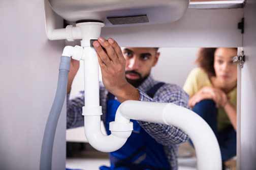 a plumber fixing a womans plumbing issues in chicago.