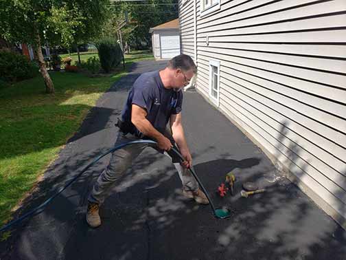 a professional hydro jet drain cleaning service being performed.