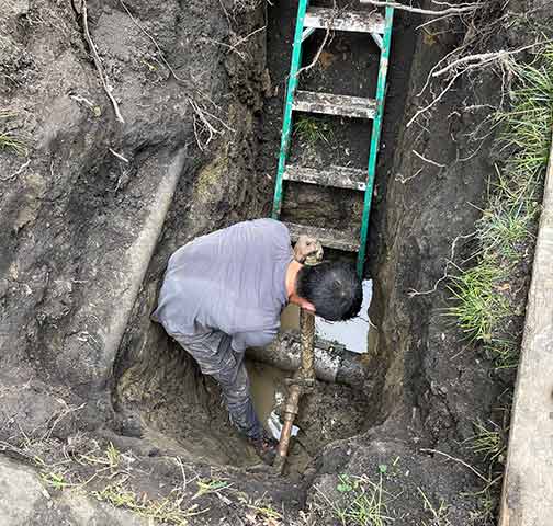 a plumber repairing a sewer line after waiting to long.