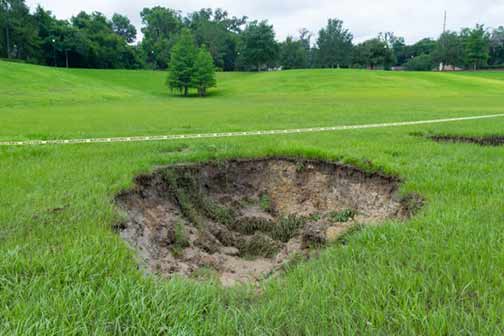 a sinkhole in a yard from a sewer leak