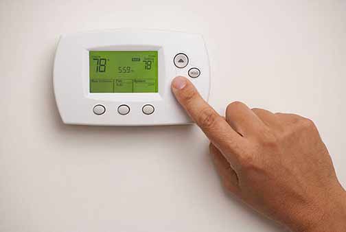 a man setting his home thermostat