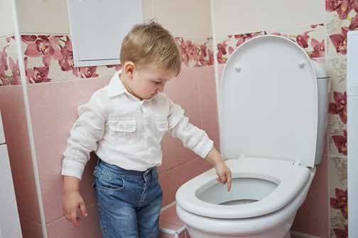 a kid putting toys down a toilet.