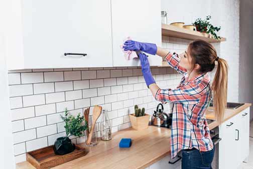 a woman cleaning her kitchen